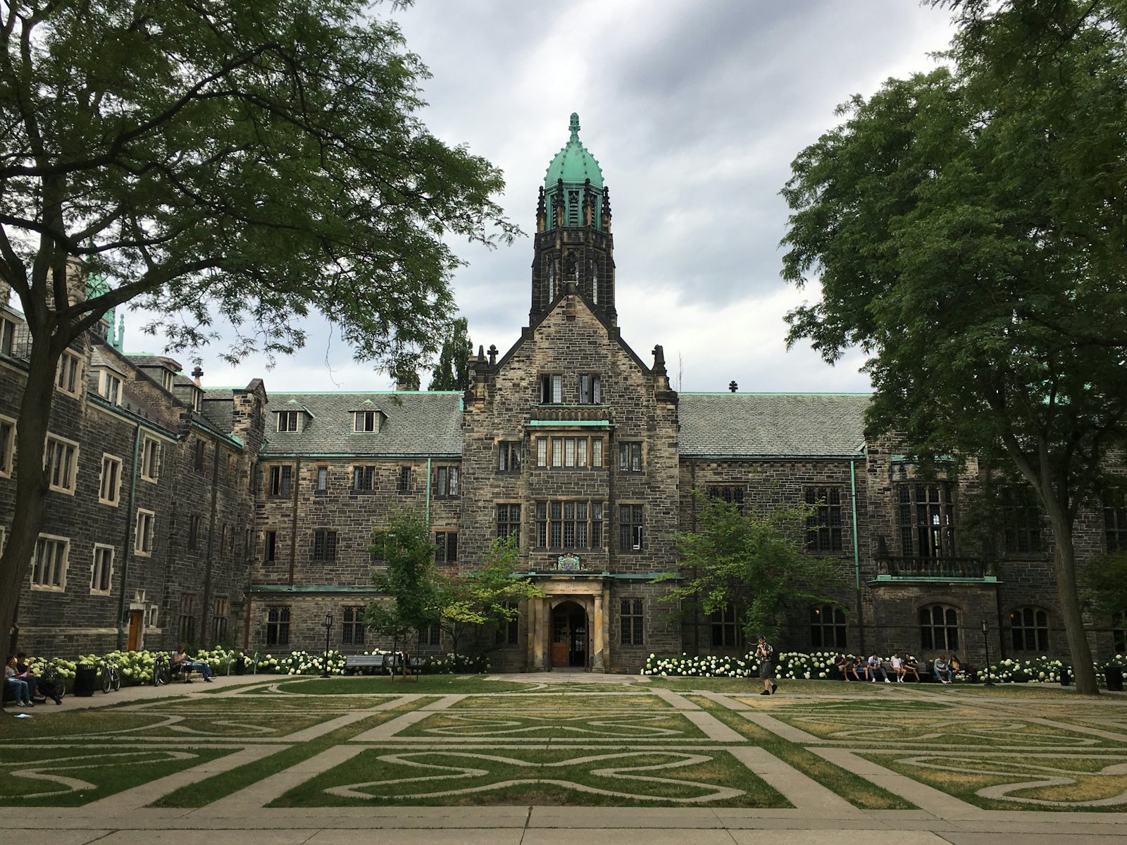 加拿大公立大学哥特式石砌建筑校园，绿草坪与古典塔楼，典型的加拿大东部大学风貌